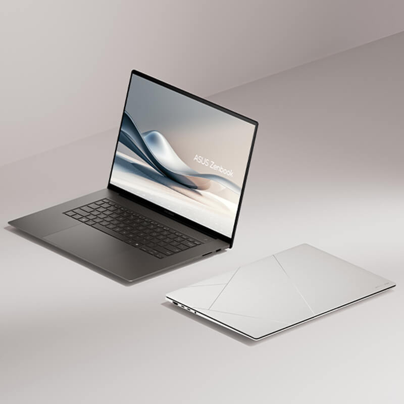 Two ASUS Zenbook S 16 OLED laptops are shown. One of them is open and viewed from the left front, while the other is closed and sitting on a flat surface.