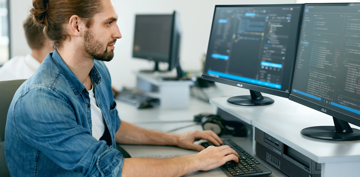 An IT employee is using the ASUS ExpertCenter desktop for work and looking at the monitor.