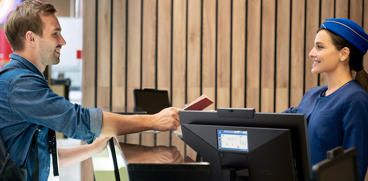 Un viaggiatore sta effettuando il check-in alla reception di un hotel. Alla reception è presente un ASUS ExpertCenter AiO.  