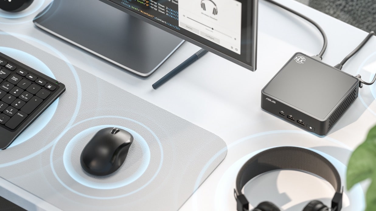 Modern workspace with code on screen, keyboard, mouse, speakers, headphones, plant, and the best mini PC for a tech-savvy vibe.