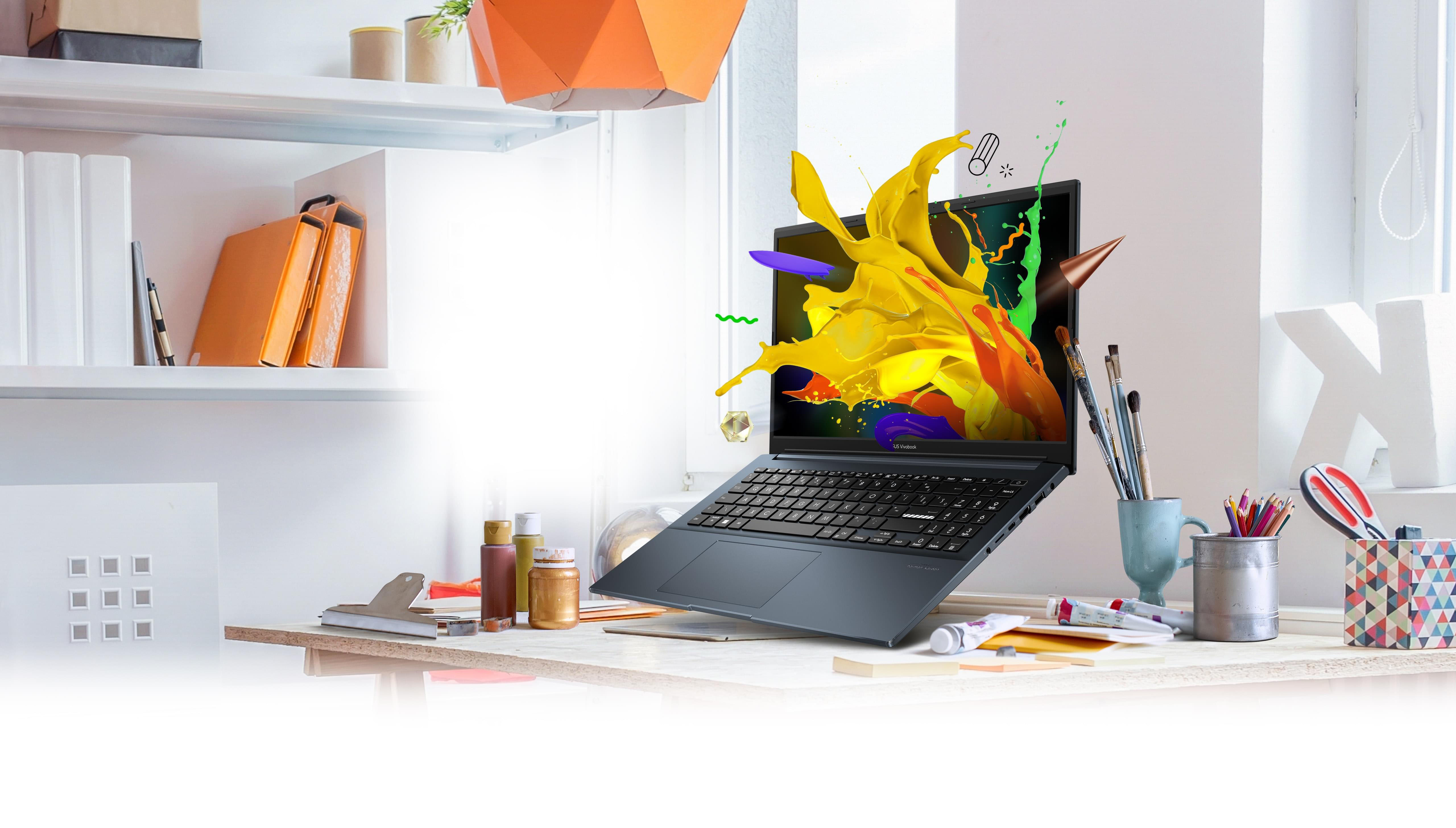 Vivobook Pro 15 OLED floating above a desk with artists’ materials and stationery. A colorful splash graphic is popping out of the screen.