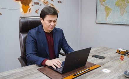 Сейтжан Сыпабеков, руководитель Galamat Group, за рабочим столом работает с ноутбуком ASUS ExpertBook