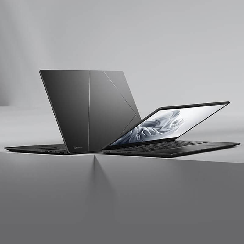 Два черных ноутбука Zenbook 14 OLED стоят спина к спине.