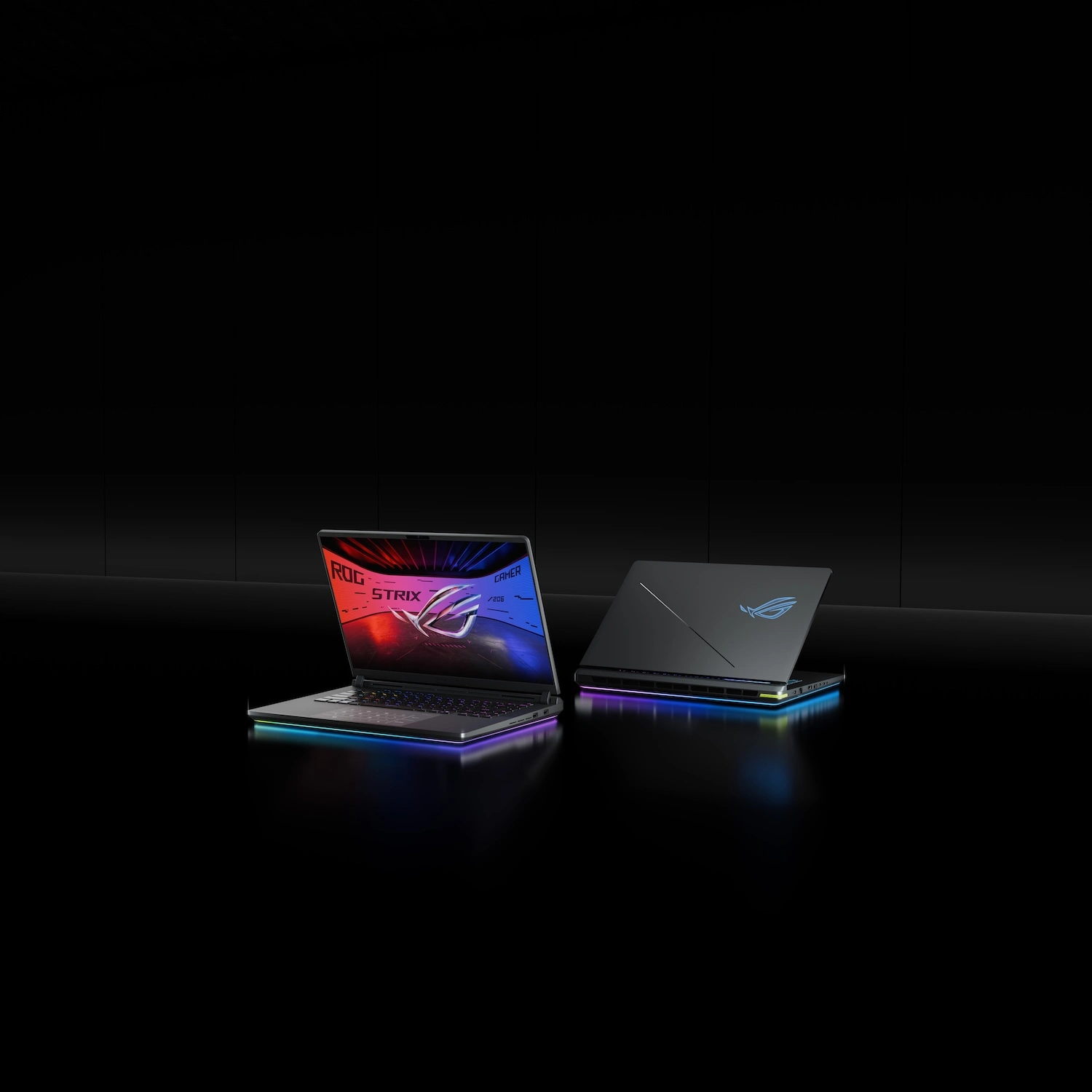 Two ROG Strix laptops on a table with the lids partially opened.