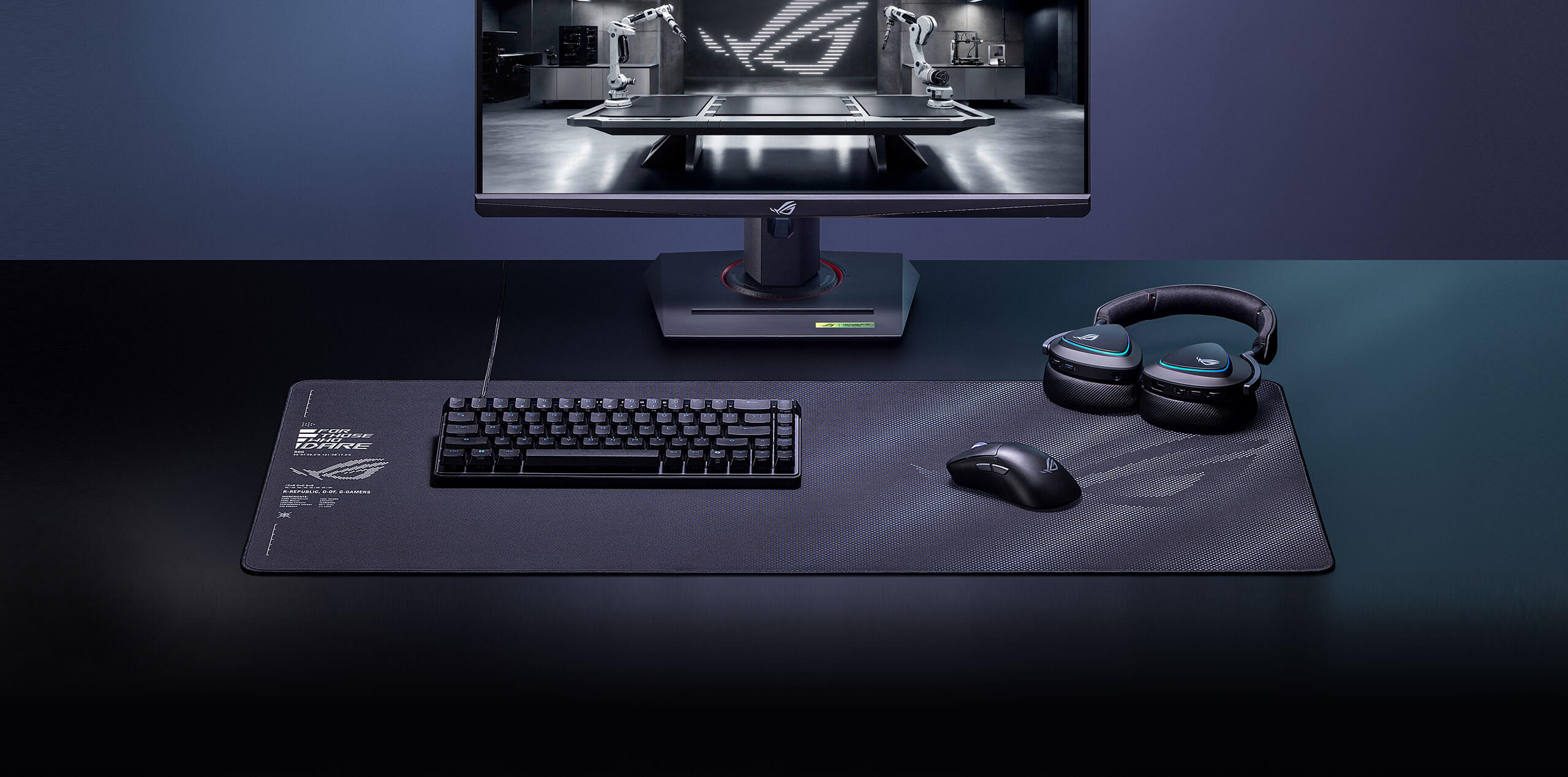 The black Sheath II XXL mouse pad set in front of a monitor, with a keyboard, mouse and headset on it