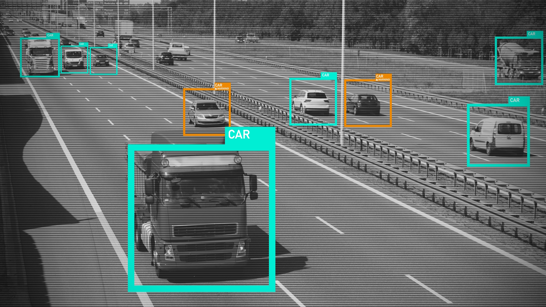 Black and white surveillance image of a highway with vehicles identified by colored boxes labeled 'CAR.'