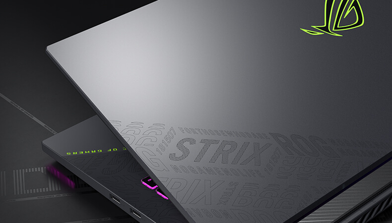 The laptop lid is shown, with the slash and ROG pattern design reflecting the surrounding light.