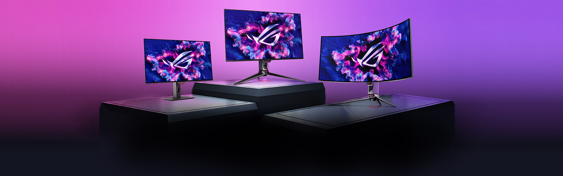 Three ROG monitors on the stage stand in front of the colorful backdrop.