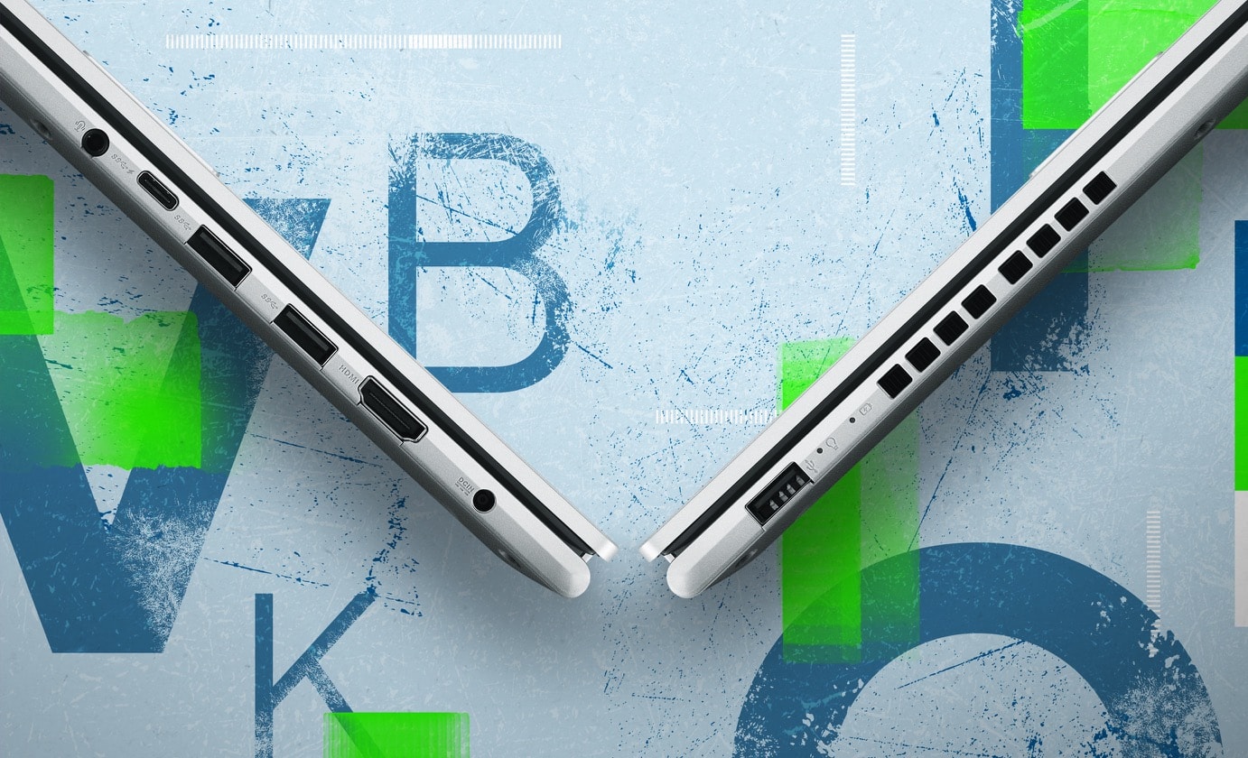 Two Vivobook 15 are closed and shown from left-side and right-side views forming a V-shape, presenting I/O ports from left to right — an audio jack, a USB 3.2 Gen1 Type-C, two USB 3.2 Gen1 Type-A, a HDMI, a DC-in 1.4 and a USB 2.0. 