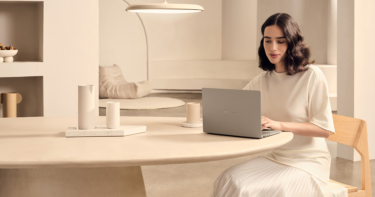 A girl using thin and Light ASUS laptop placed on a desk.