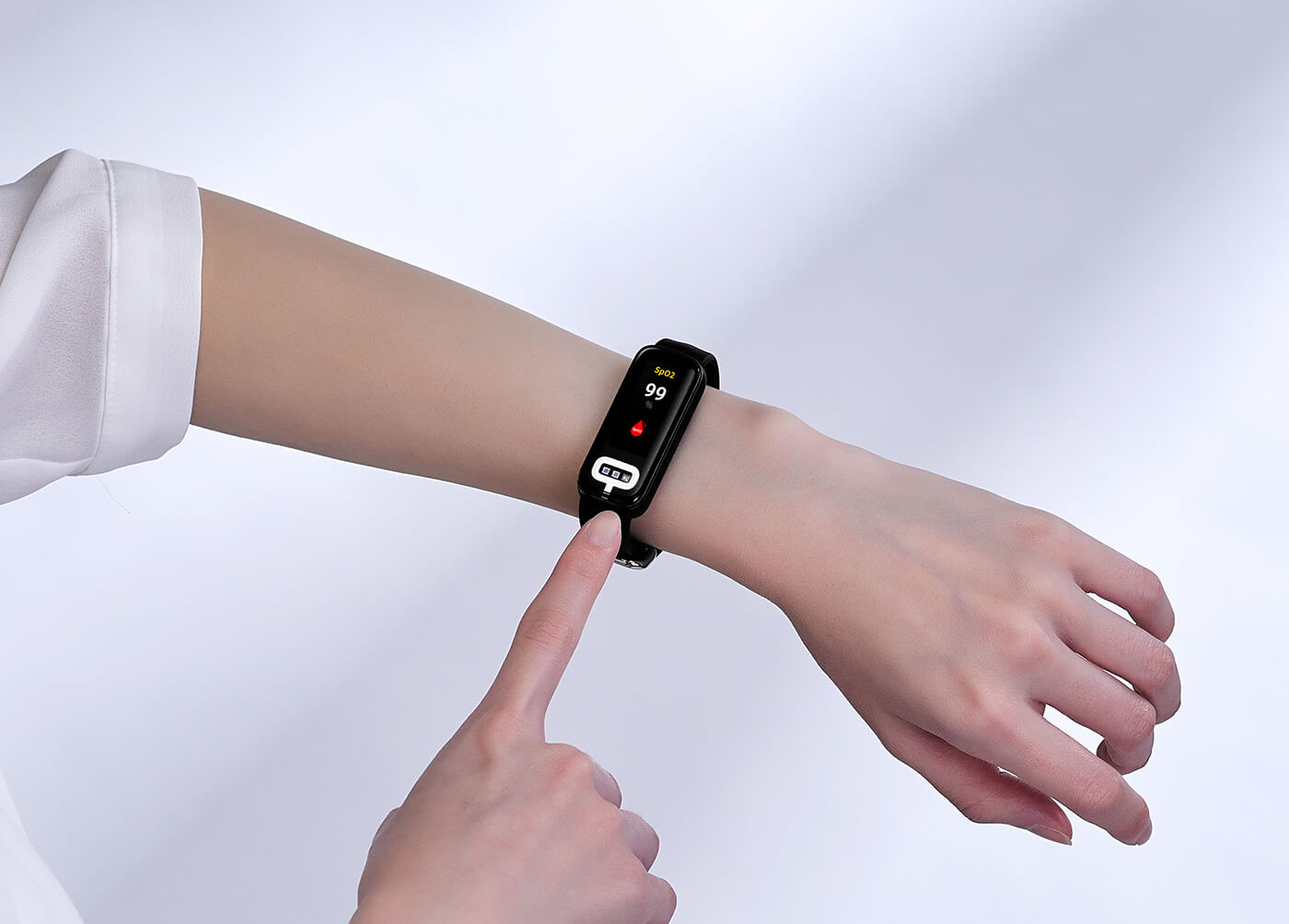 A female is wearing smart band on her wrist and her finger is touching sensor to measure blood pressure