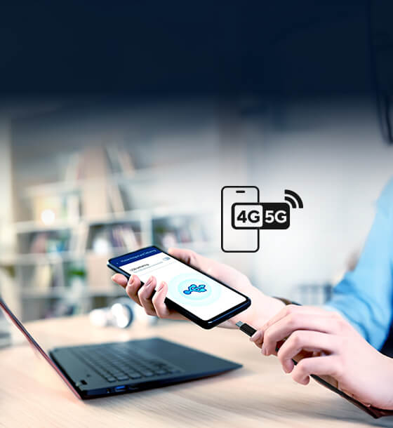 Hands connect a USB cable from a smartphone displaying a setup screen to a laptop.