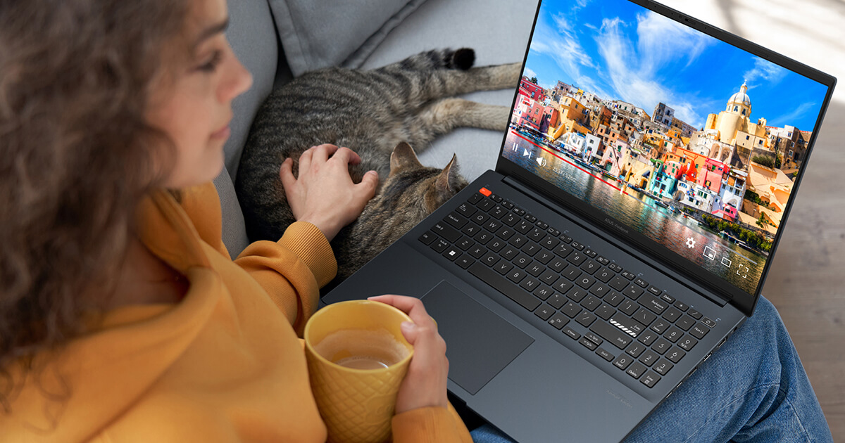 A woman watching a video on a colorful OLED screen of ASUS Vivobook Pro 16 OLED.