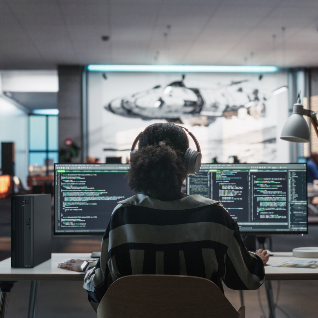 A female employee working at her desk with dual monitors and ASUS ExpertBook B series
