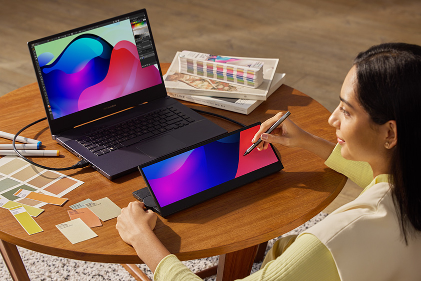 A woman takes advantage of one of OLED's features: color accuracy as she adjusts the accurate color of the painting by the small panel of ProArt Studiobook Pro 16 OLED.