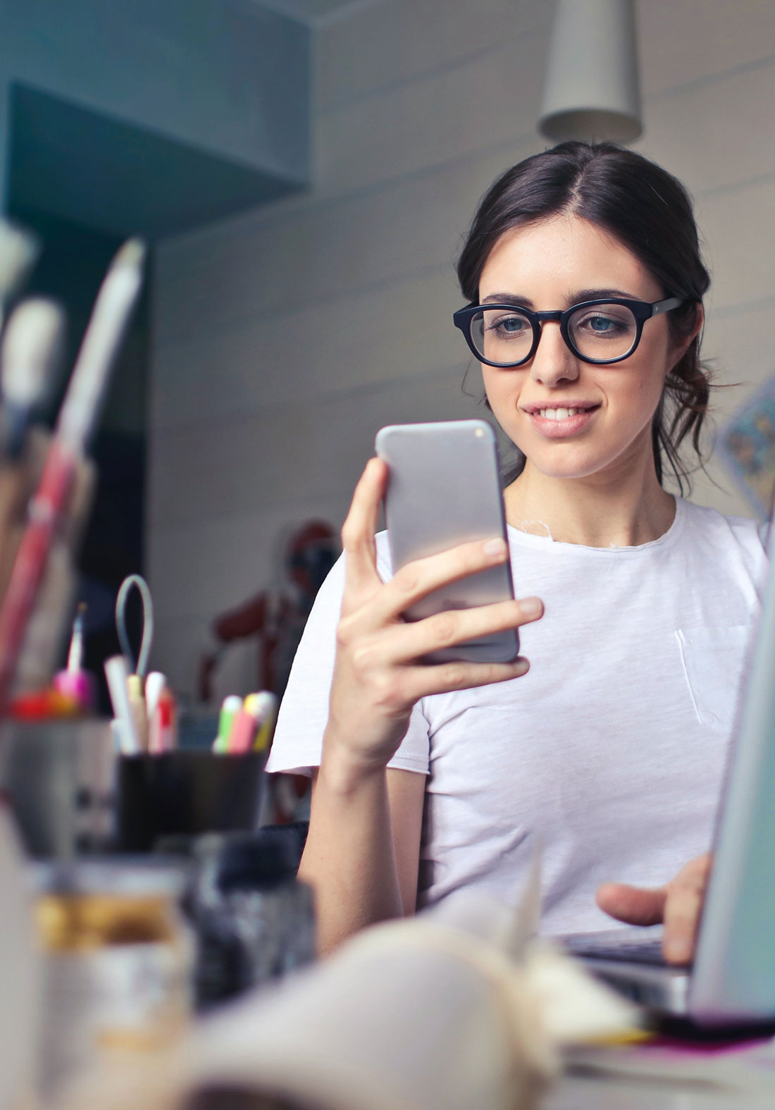 Une femme utilise son smartphone pour parcourir des informations sur l'application ASUS Router