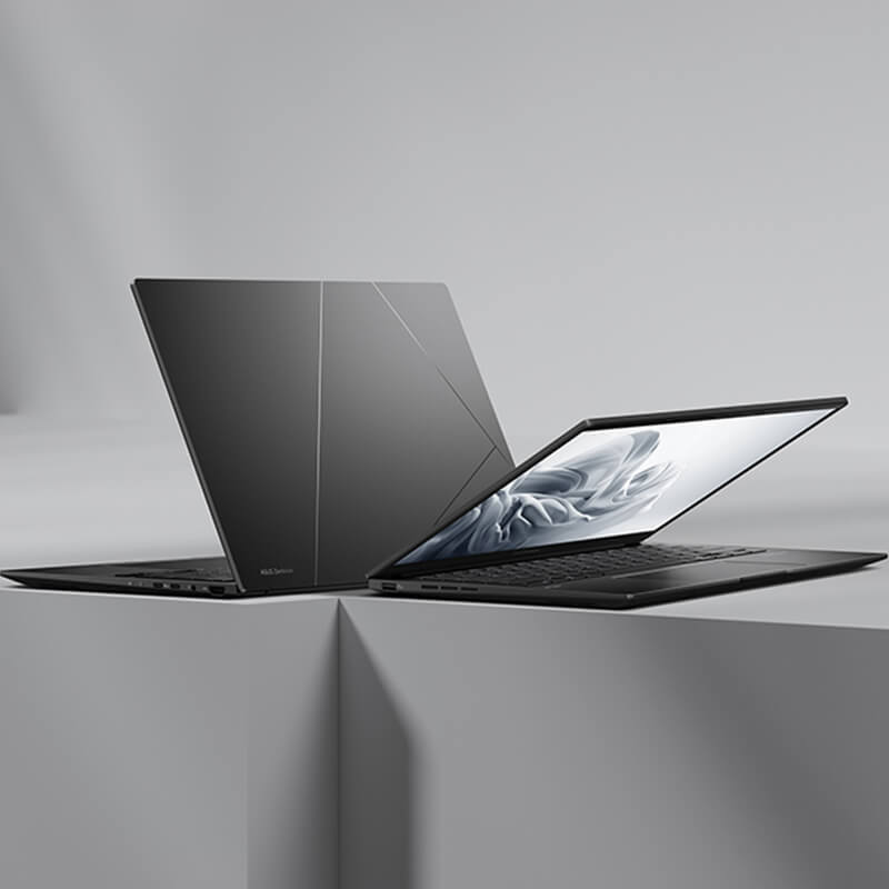 Два черных ноутбука Zenbook 14 OLED спиной к спине на сером фоне.