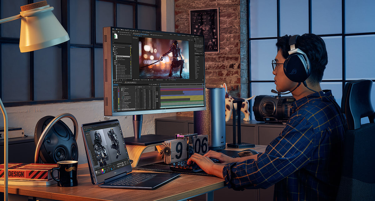 A professional content creator is using ASUS ProArt Studiobook laptop and ProArt Monitor to edit a video on his workstation desk. Adobe product screenshot(s) reprinted with permission from Adobe.