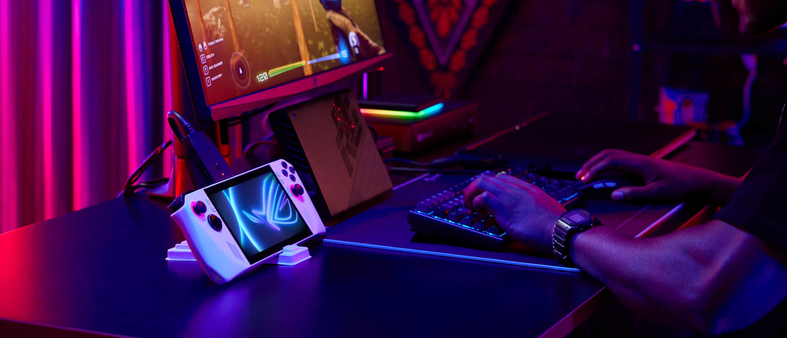 Person sitting at a desk with a keyboard, mouse, and external monitor, and with their Ally connected to the system and an XG Mobile, playing a competitive game.