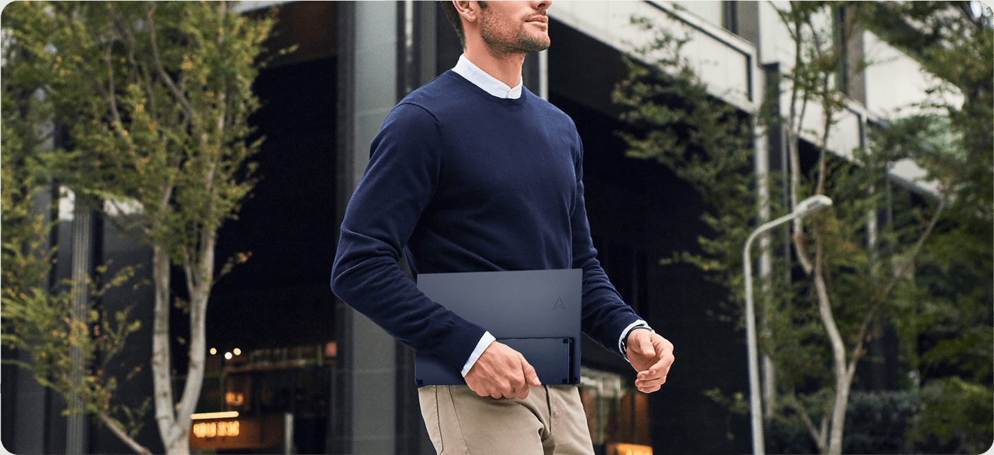 City scene, a man heading to work, carries the ASUS ZenScreen portable monitor in his left hand effortlessly