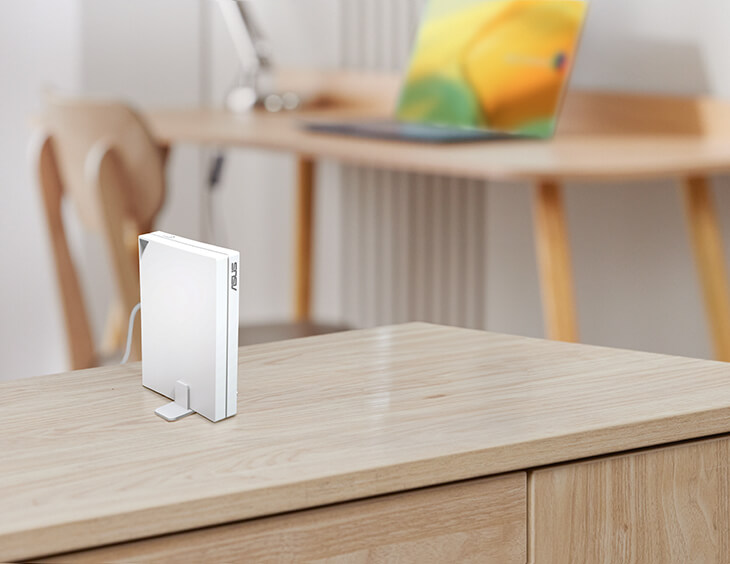 RT-AX57 Go is placed on a side cabinet using the included stand in the study of a home setting.