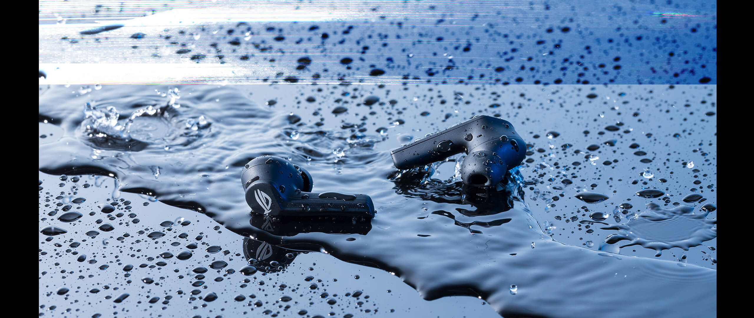 De ROG Cetra True Wireless Earbuds liggen in een plas water om de waterbestendigheid te demonstreren