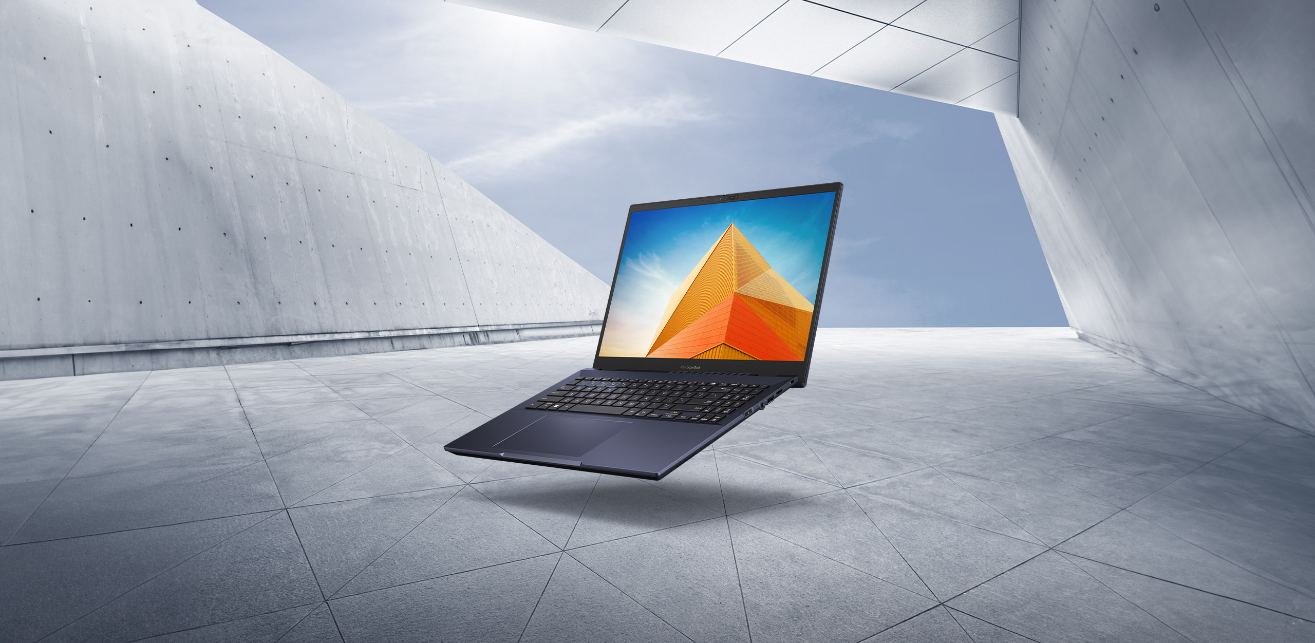 ASUS ExpertBook B5, sur fond de ciel bleu et d'architecture minimaliste.