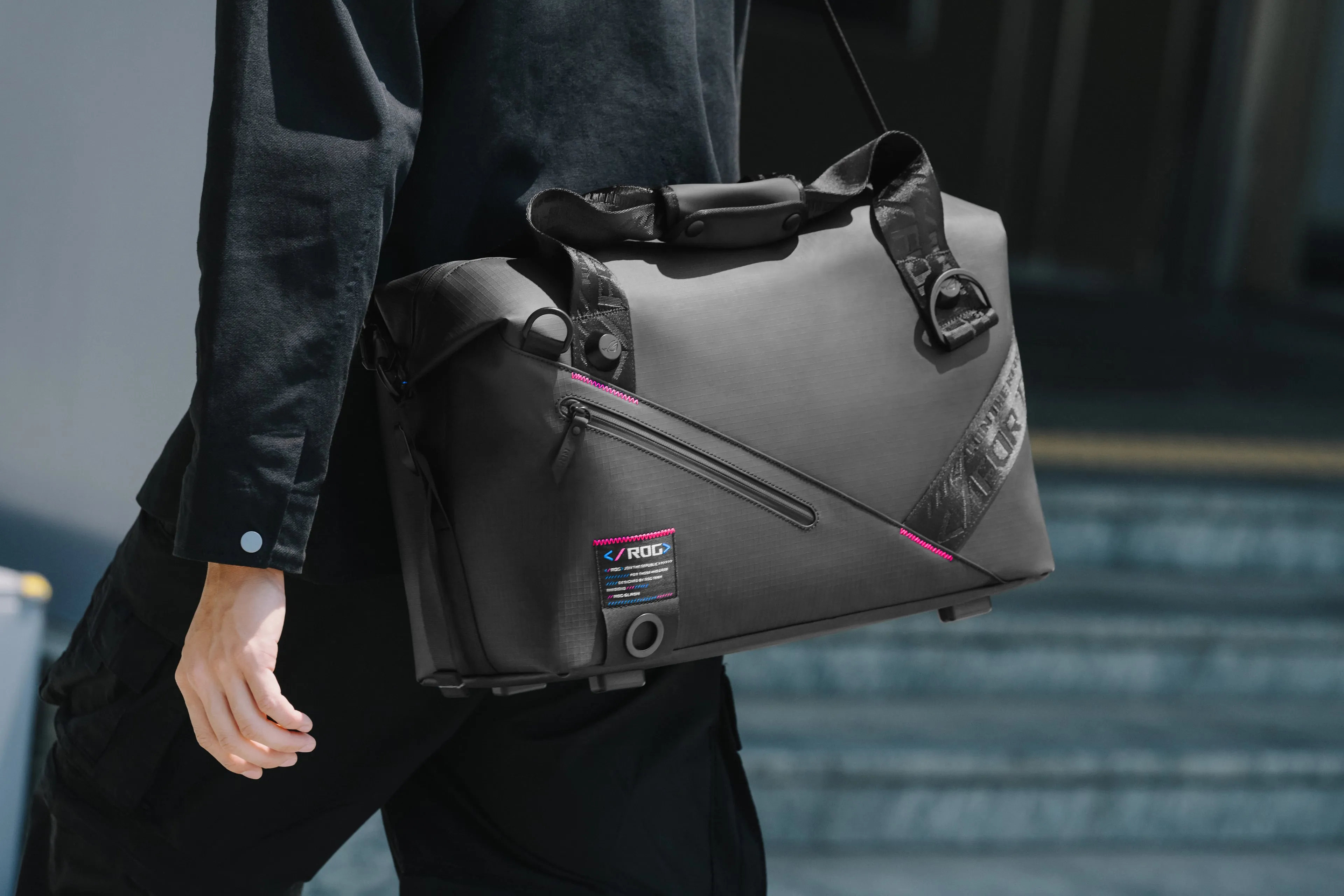 Image of a person wearing the ROG SLASH Duffle Bag over their shoulder, with ROG branding clearly visible