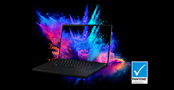 Uma imagem de um portátil sobre um fundo preto, com fumo colorido visível no ecrã e por trás da máquina com o logótipo Pantone Validated visível