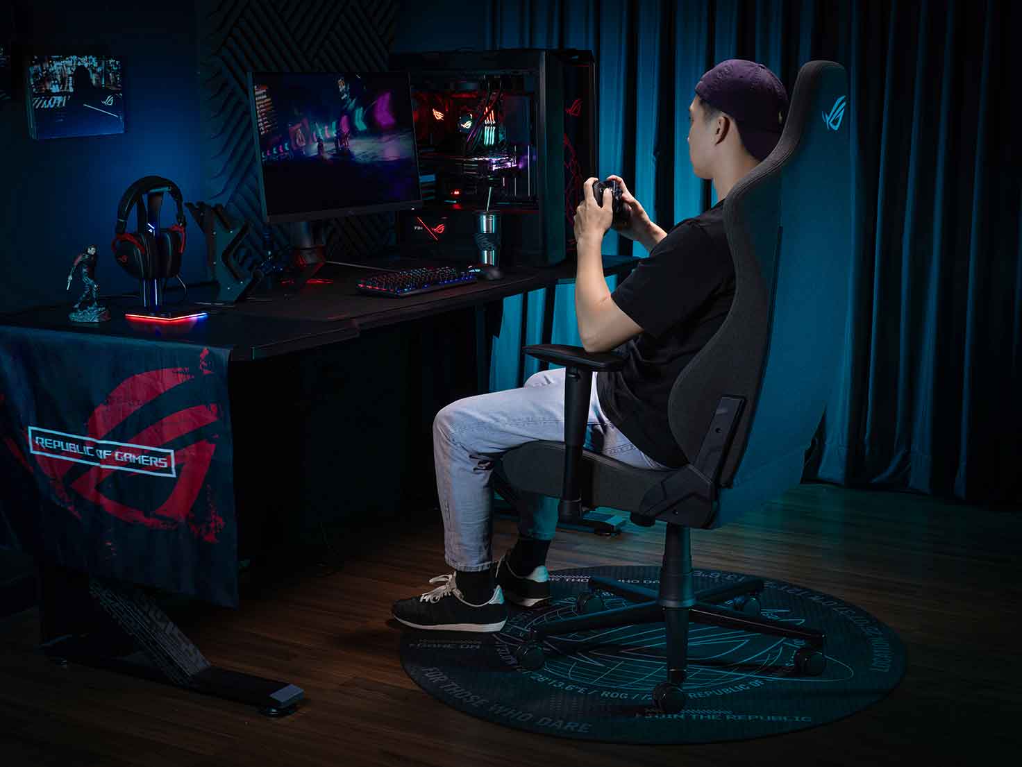 A guy sitting on the ROG Aethon and gaming