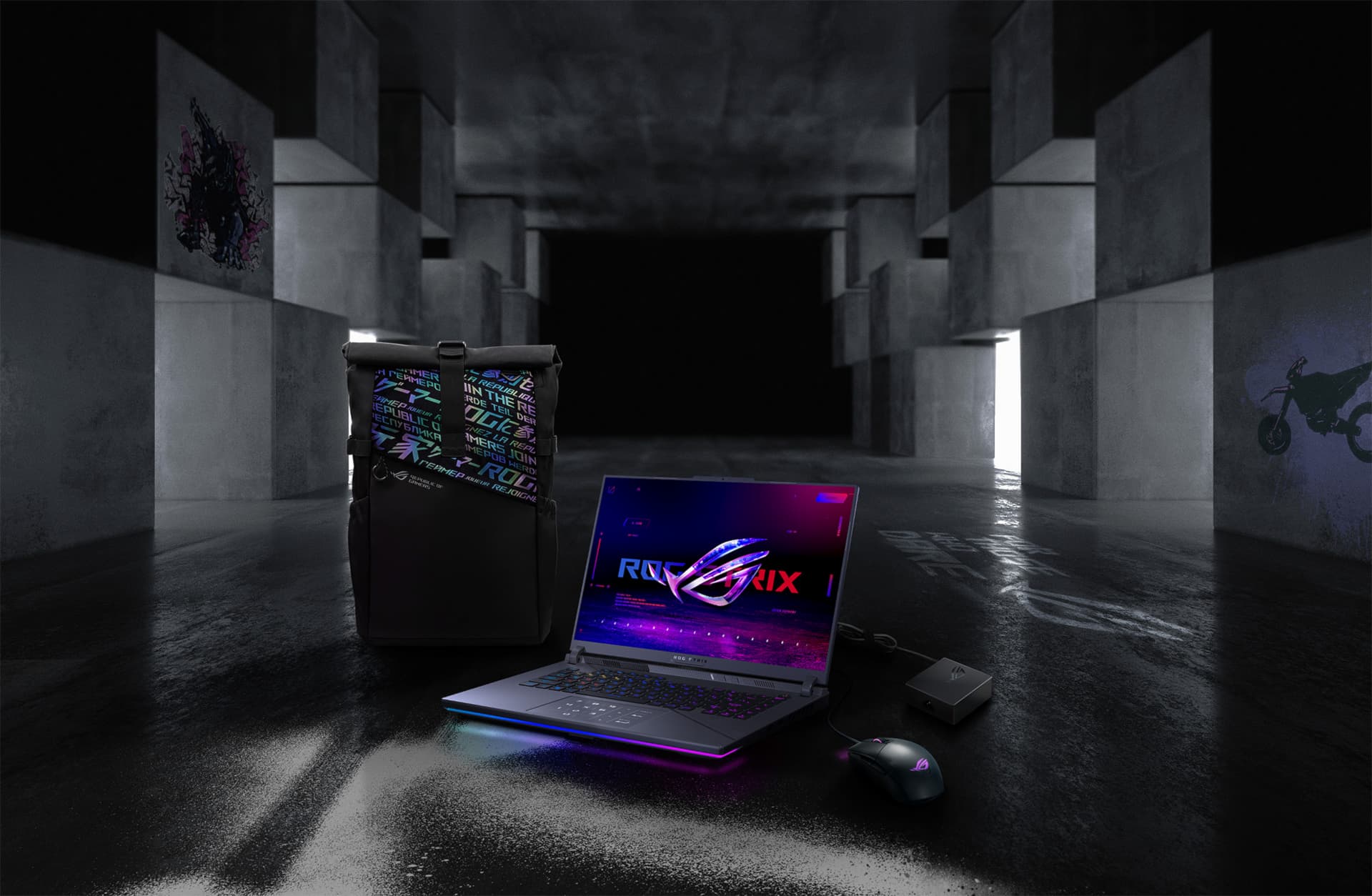 In an underground big space, from left to right; an ROG backpack, G16, ROG Strix Gladius III mouse, and 100W adapter.