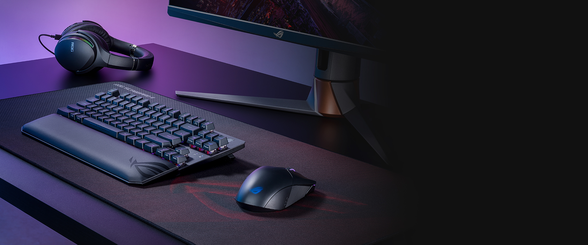 A side view of a desktop setup. The ROG Strix Scope RX TKL Wireless Deluxe sits on the left end of the Scabbard II mousepad, leaving much space for mouse movement on the right side of the mousepad.
