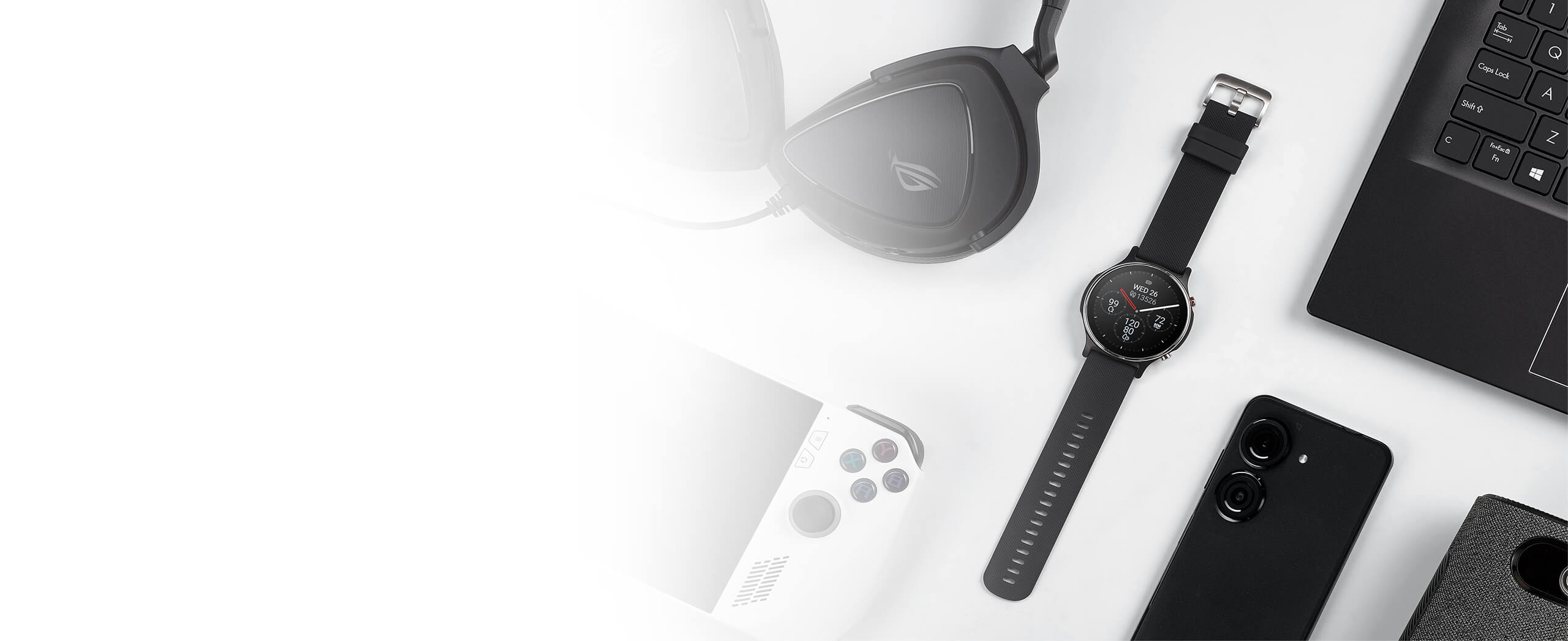 On the white table there are gaming headset, game console, ASUS VivoWatch 6, smart phone and notebook from left to right side
