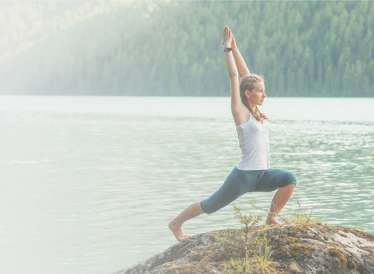 A female is doing yoga at lakeside with smart watch and smart phone App showing statistics