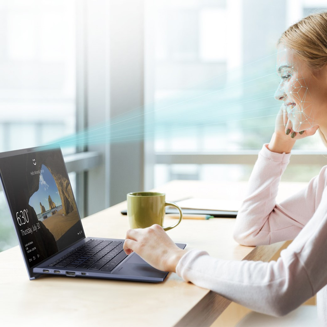 An employee is using Windows Hello face recognition to log in to her ASUS laptop.