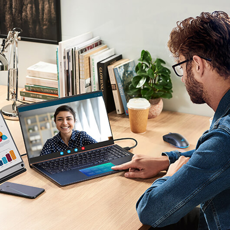 A man starts his work-from-home day by joining an online meeting on the laptop with the data demonstrated on the monitor at the same time. His phone is at hand