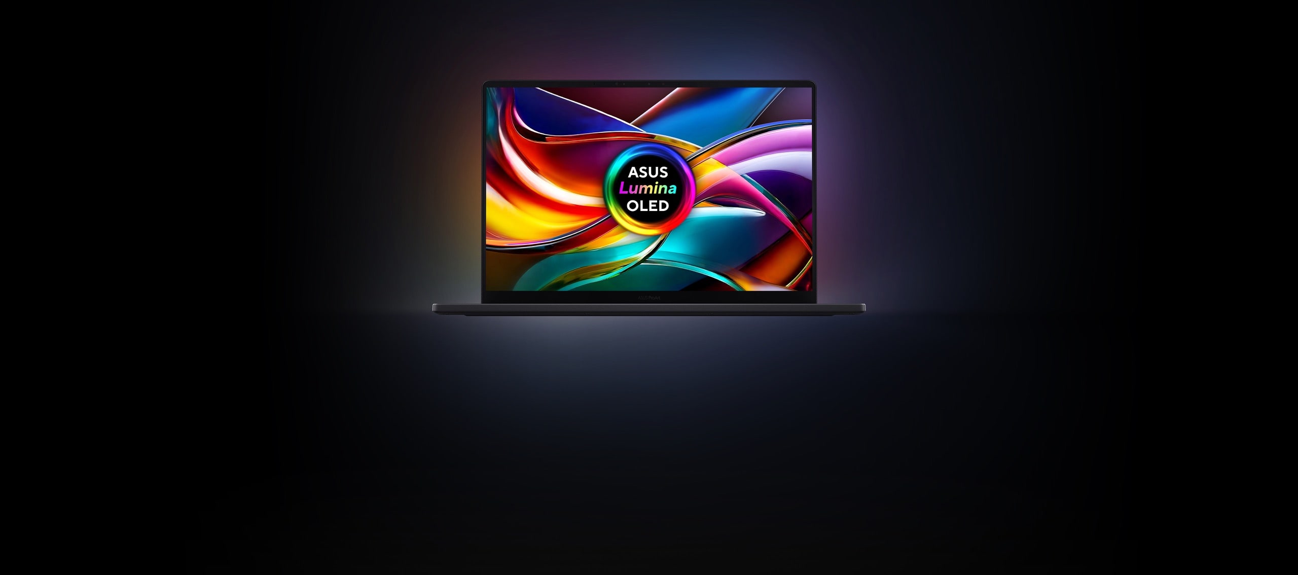 Front view of a laptop displaying vibrant, colorful crystal structures on the screen, with the ASUS Lumina Pro logo centered prominently. 