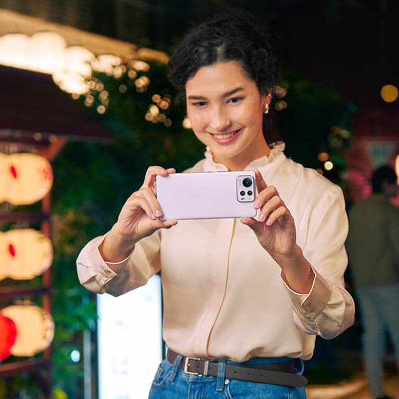a woman is smiling while clicking a pictiure with the Zenfone 12 Ultra.