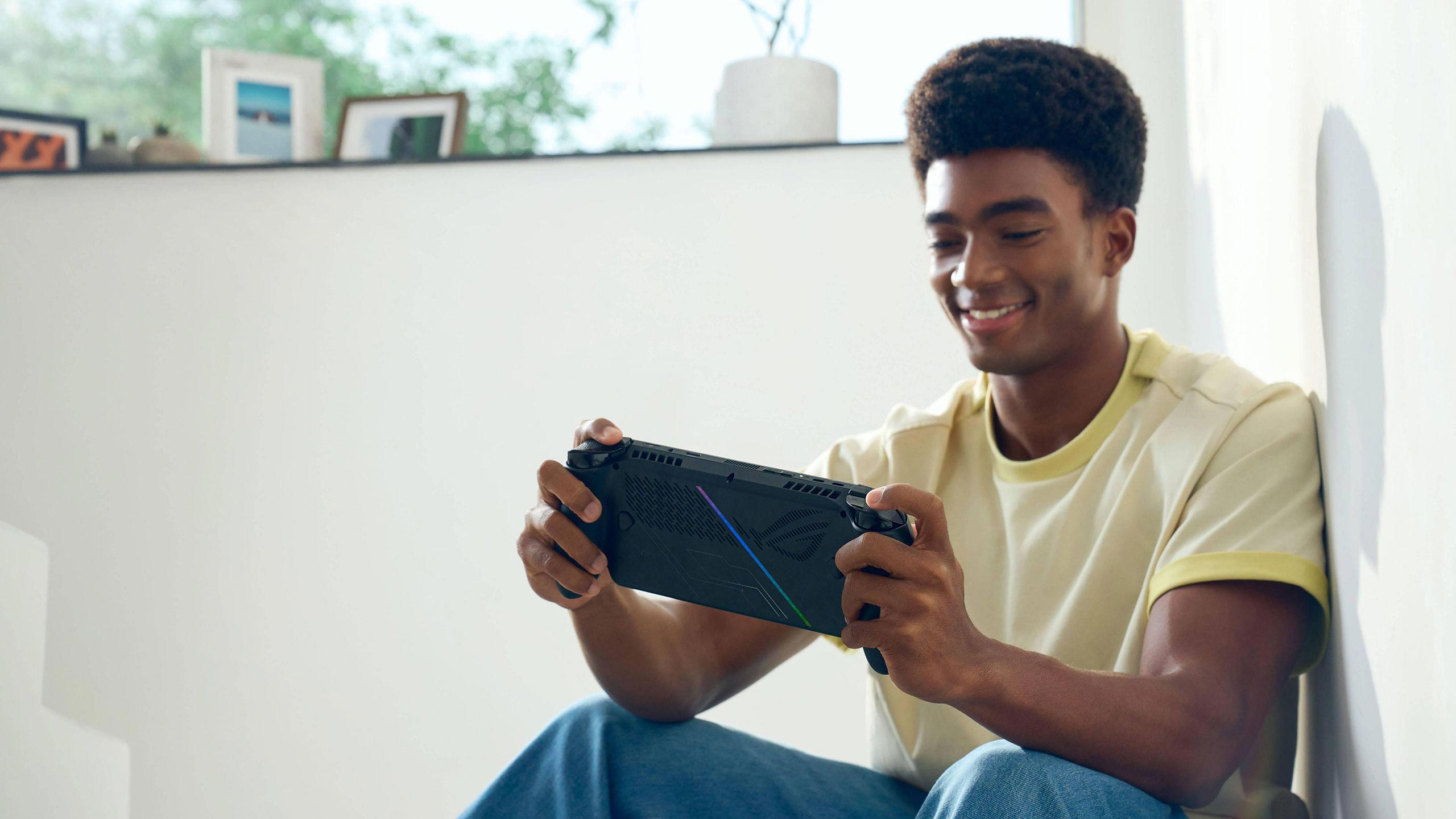 A person sitting on a staircase playing with an ROG Xbox Ally.