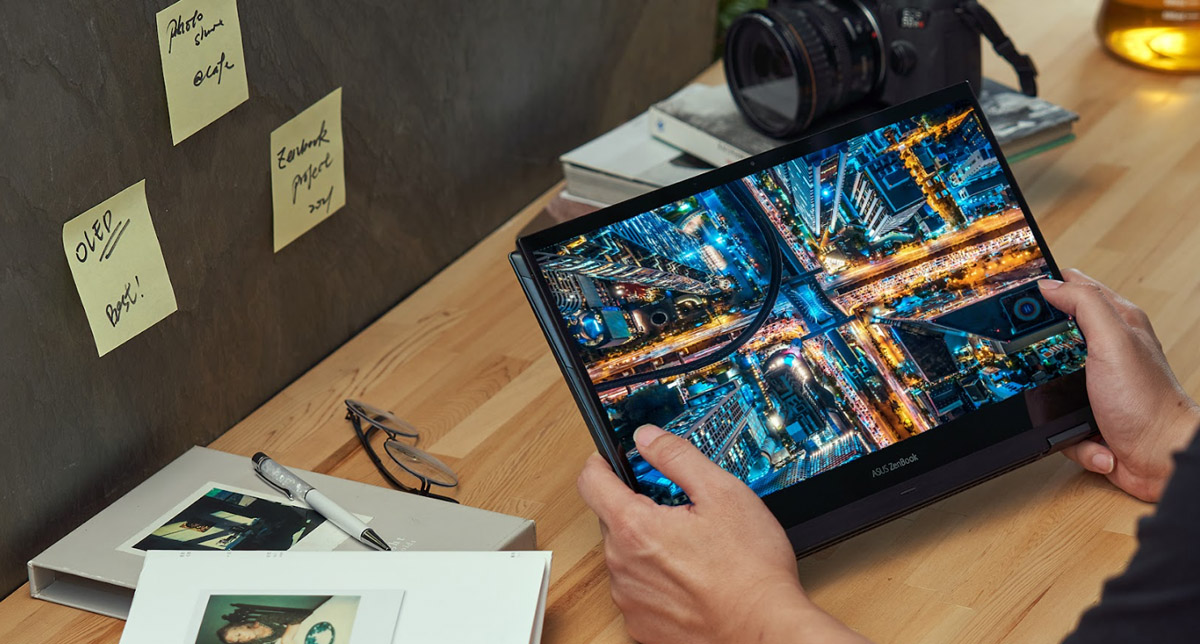 ASUS Zenbook Flip 13 OLED Intel® Evo™ convertible 2-in-1 laptop with OLED display being used in Tablet Mode to display colorful high-resolution photo at the desk next to a camera