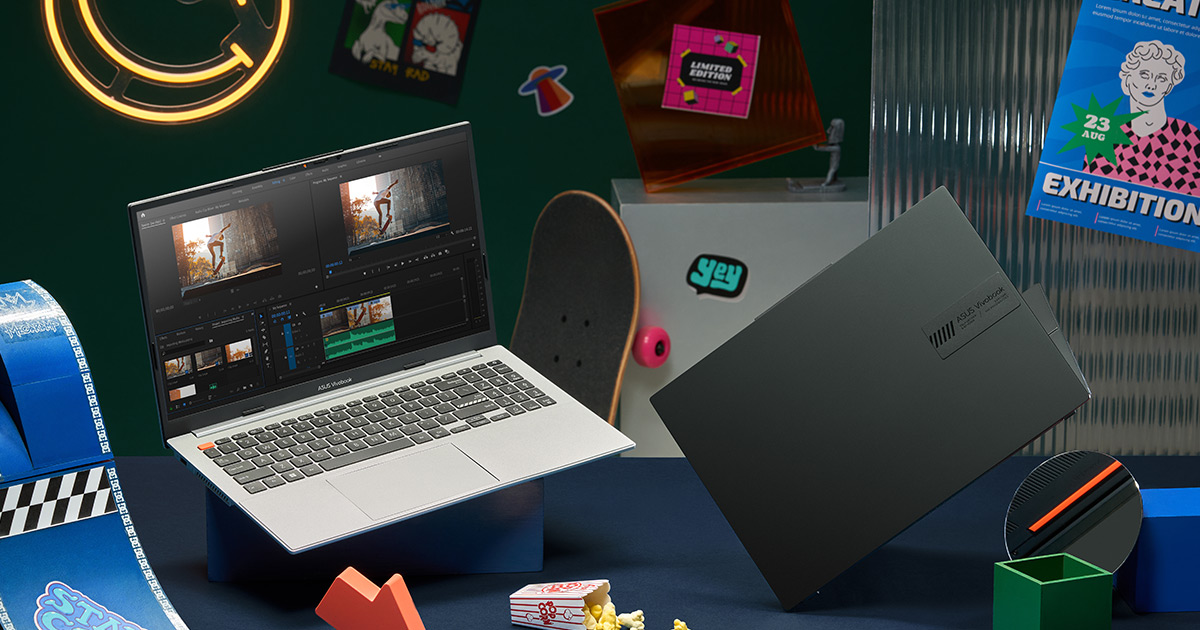 this icon is two ASUS Vivobook S 14/15 OLED laptops in Cool Silver and Midnight Black colors with open screens lying among toys and other objects, with pictures and neon smiling face lights in the background.