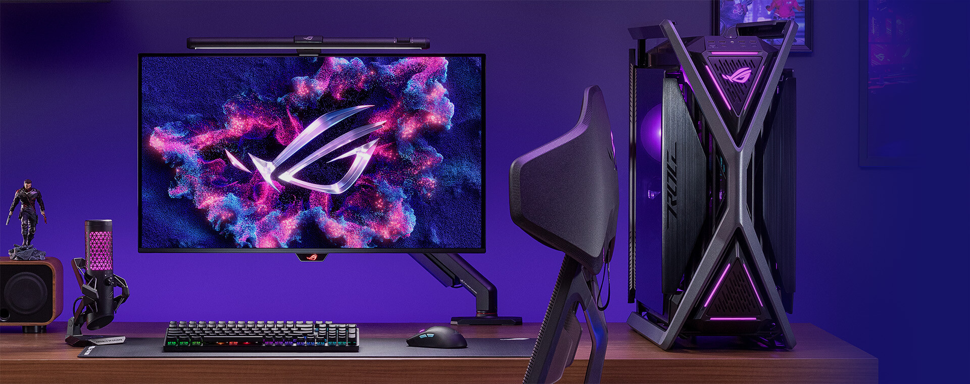 A full table set up showcasing the ROG monitor with a mouse, a keyboard and a microphone on the side