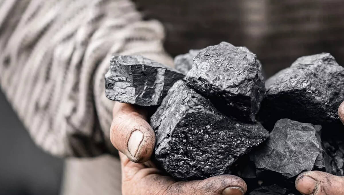 two hands holding a few chunks of ore