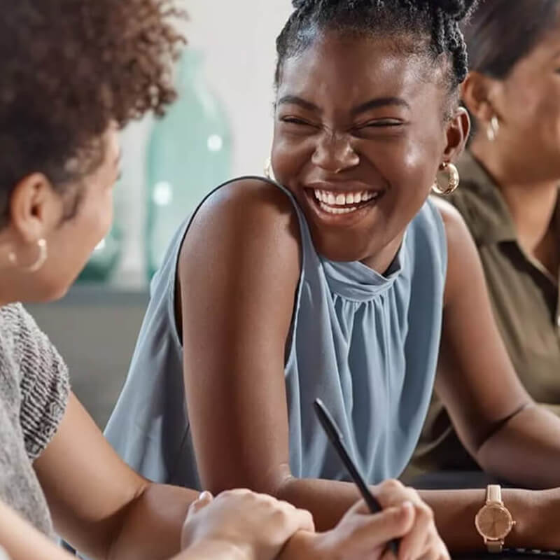 A young woman smiles while looking at a person in a diverse group of people