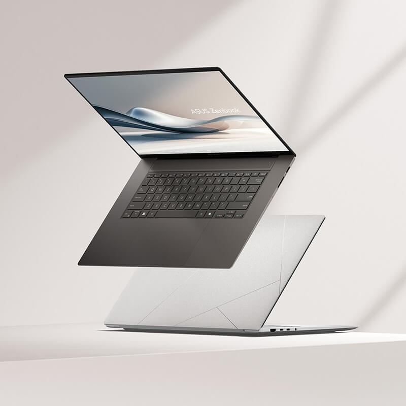 Two Zenbook S 16 laptops, one of them opened at 100 degrees and viewed from the left front, while the other one is closed and placed on the ground.