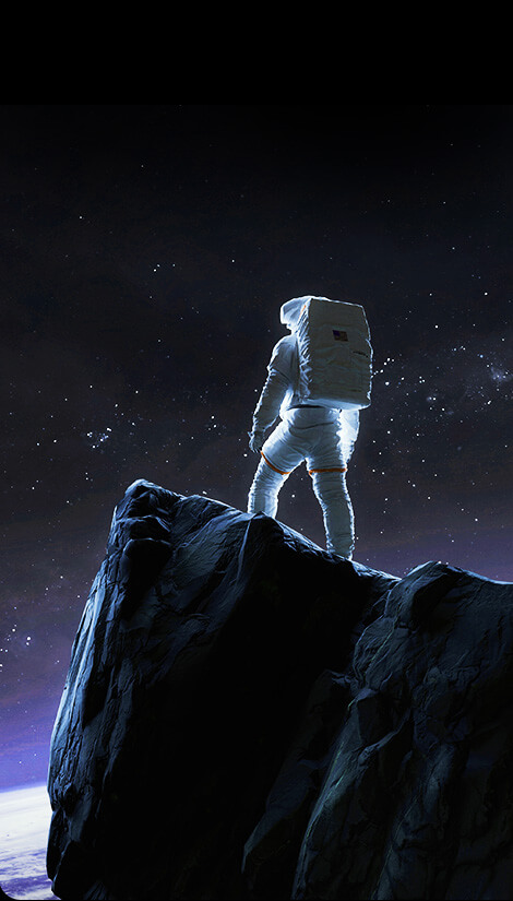Astronaut stojí na útesu a dívá se na noční oblohu