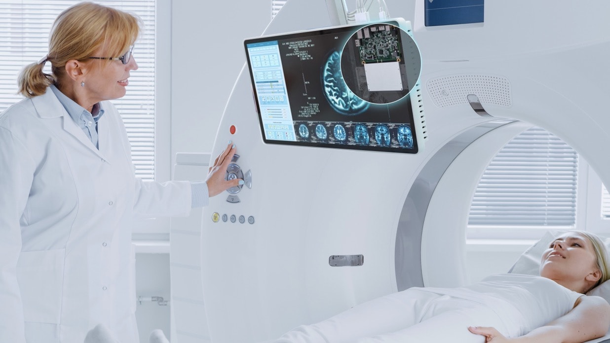 Lekárka používa obrazovku lekárskeho displeja so zabudovaným výpočtovým prvkom NUC Pro 13 na vysvetlenie situácie pacientu ležiacemu na CT.