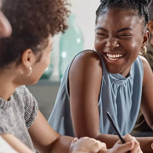 A young woman smiles while looking at a person in a diverse group of people