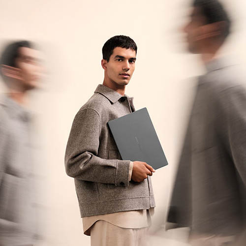 Dört öğrenci, kütüphanedeki bir masanın üzerinde duran açık bir ASUS Chromebook dizüstü bilgisayarın etrafında toplanıyor