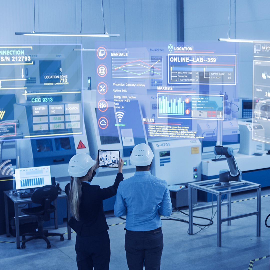 Two engineers holding a tablet, monitoring AI-powered smart factories. The dashboards contain factory and machine information, and status, which are projected from the AR technology.